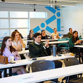 MIIPS students offer applause in a classroom after a presentation